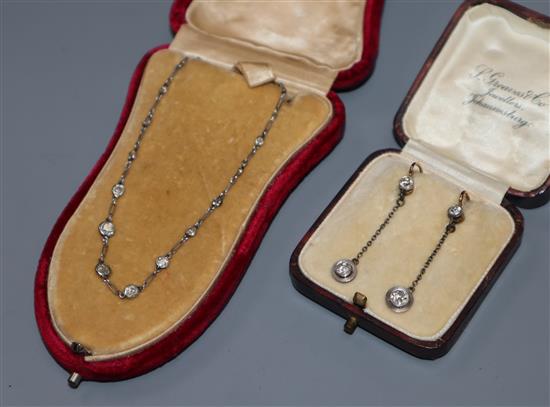 A diamond and white metal (tests as platinum) necklace set 14 old cut diamonds and a pair of diamond drop earrings.